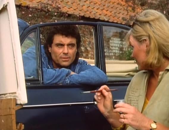 Lovejoy leaning out of a car window, unimpressed, talking to a woman holding a paintbrush and palette